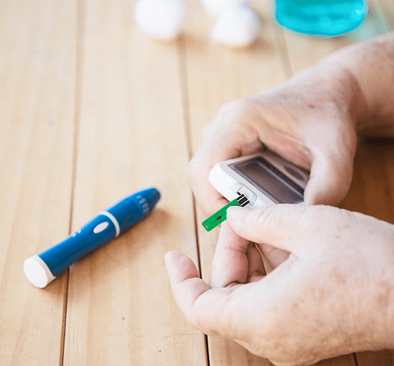 Patient testing their blood glucose level with a glucometer.
